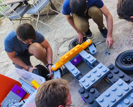Compañeros montando un coche con bloques gigantes en el Block Car Challenge