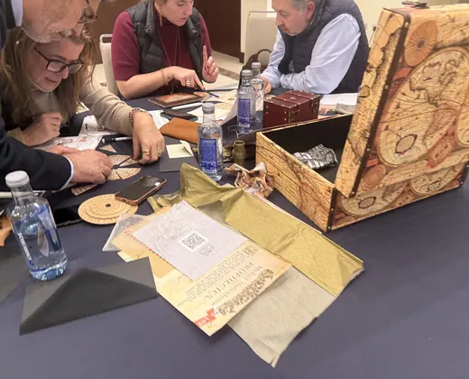 Equipo resolviendo pistas alrededor de un baúl antiguo y un mapa en un escape room de Acuilae